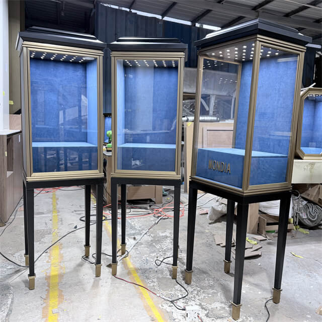 Freestanding jewelry tower display case with brass-accented black pedestal legs, blue velvet interior, and LED lighting — Shangyuan Display